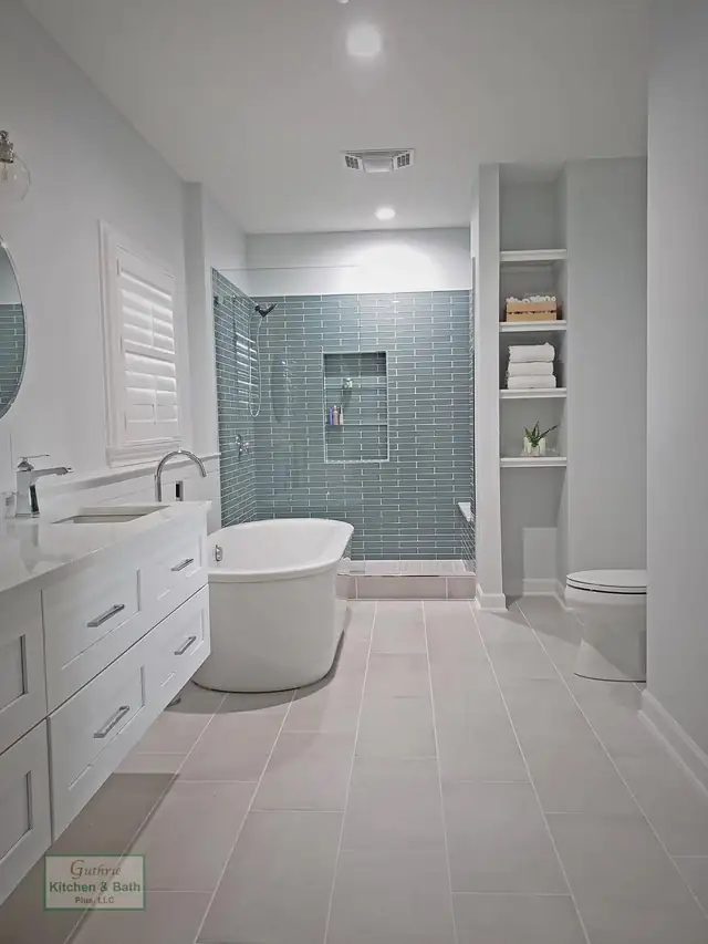 Springfield, TN bathroom with a white drawer vanity, freestanding tub and blue-green glass tile shower