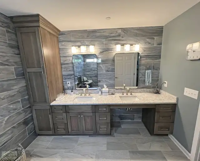 Pleasant View, TN bathroom with a double vanity, gray wood-look tile accent wall and tall linen cabinet