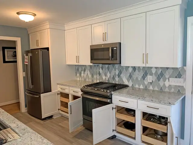 White Shaker kitchen with a blue diamond tile backsplash, gas range, stainless refrigerator and open rollout shelves