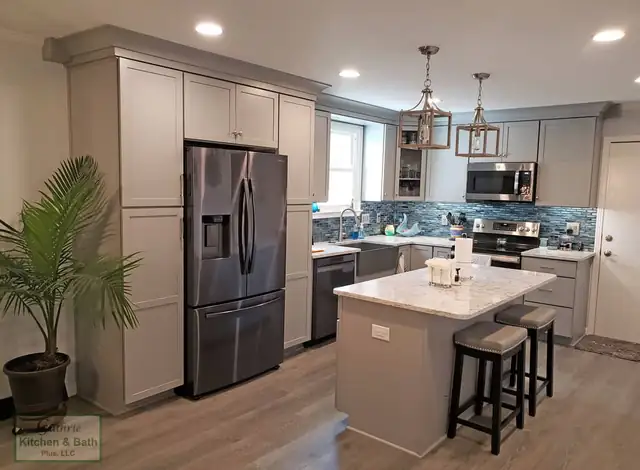 Clarksville, TN kitchen with gray cabinets, a small island with two stools and lantern pendants